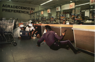 ©Enrique Metinides, Operativo que se realizó en un supermercado de la cadena Comercial Mexicana, luego de que fuera asaltada la camioneta de trasnportes de valores. La policía y los aslatantes  estaban en plena  balacera, la demás gente, pecho tierra. Los asaltantes huyeron por la puerta trasera. México DF.,  septiembre de  1988